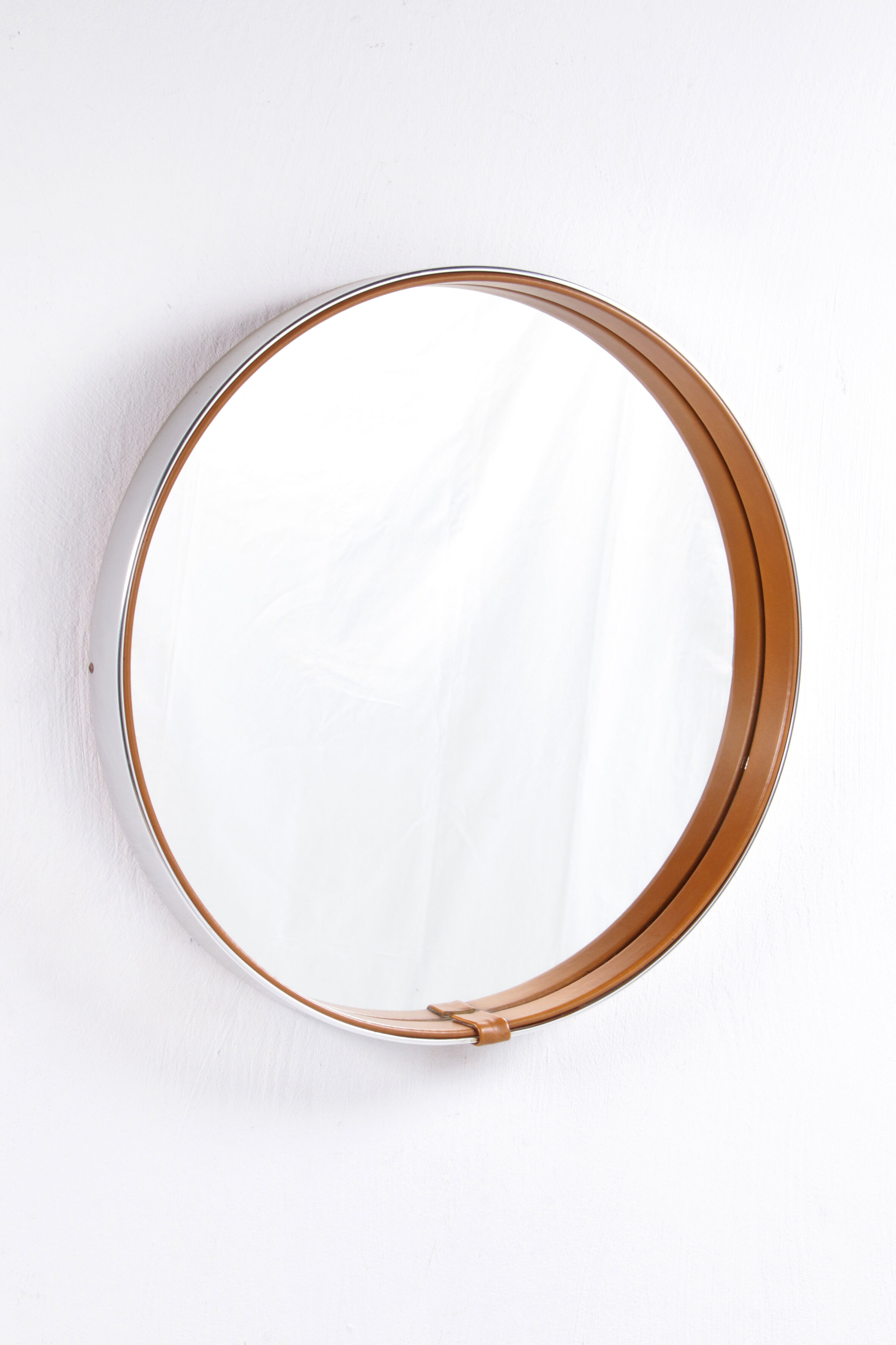 Round mirror covered with leather and chrome, made in France in the 1970s.