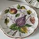 Set of three earthenware plates from Bassano, hand-painted with fruit and flower designs.