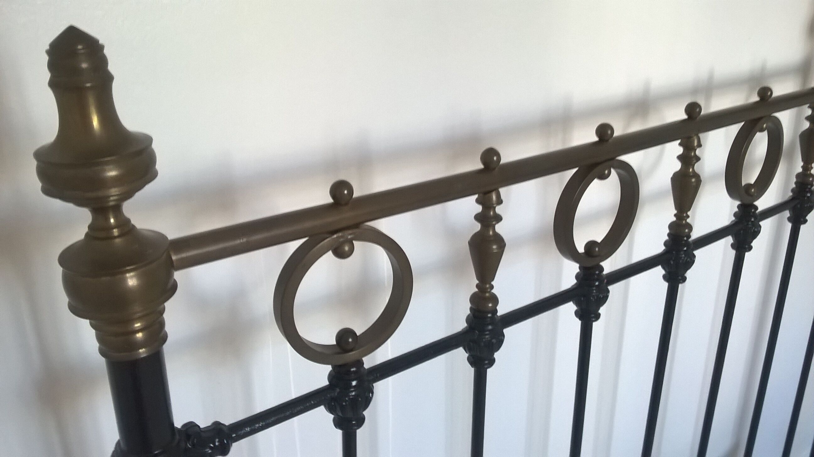 Old bed in black iron and brass