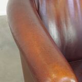 Comfortable, rugged cognac-colored sheepskin club armchair with a characteristic seat cushion
