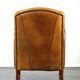 Luxurious cowhide Art Deco design armchair with wooden armrests and cognac-colored leather