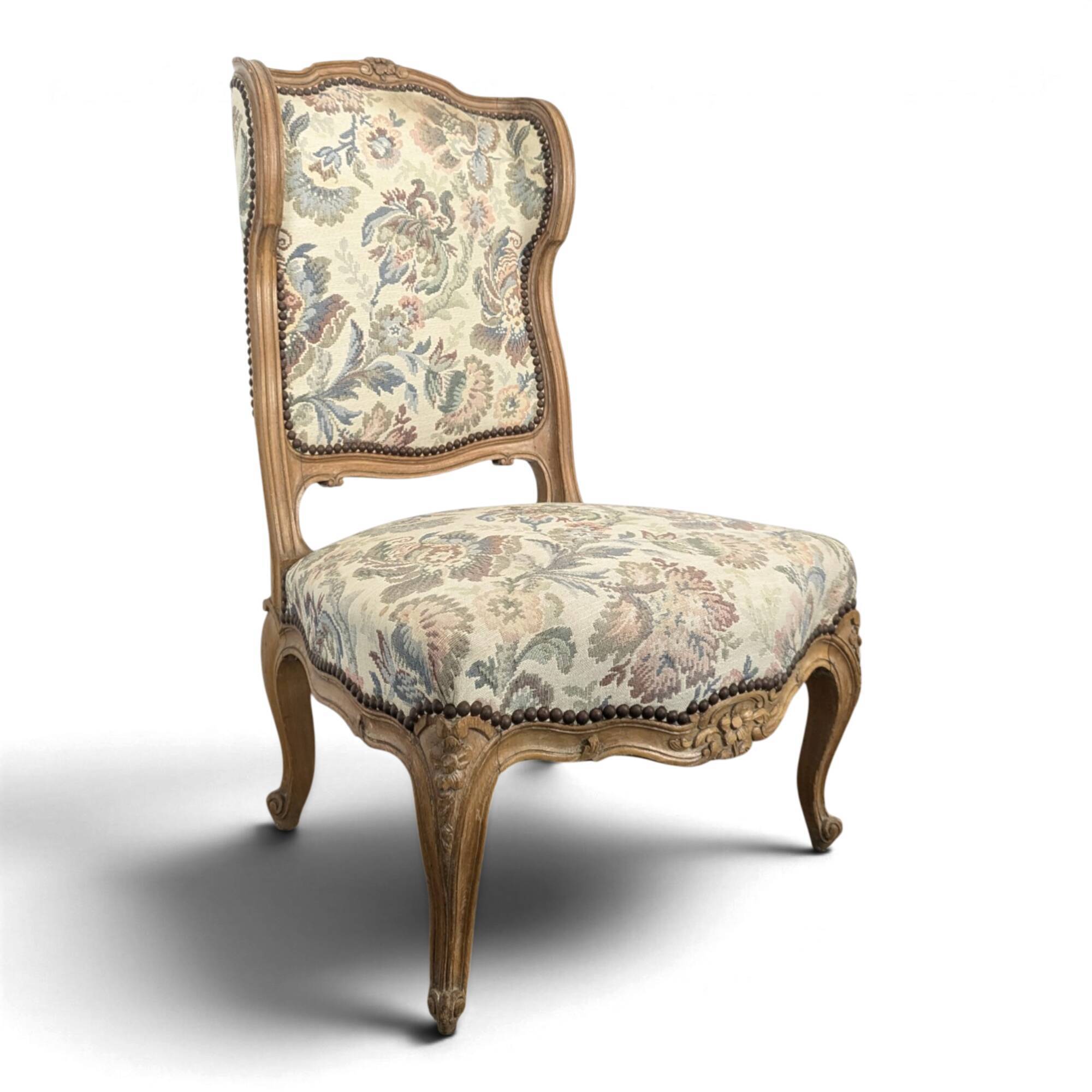 Louis XV style armchair in natural wood with floral fabric.