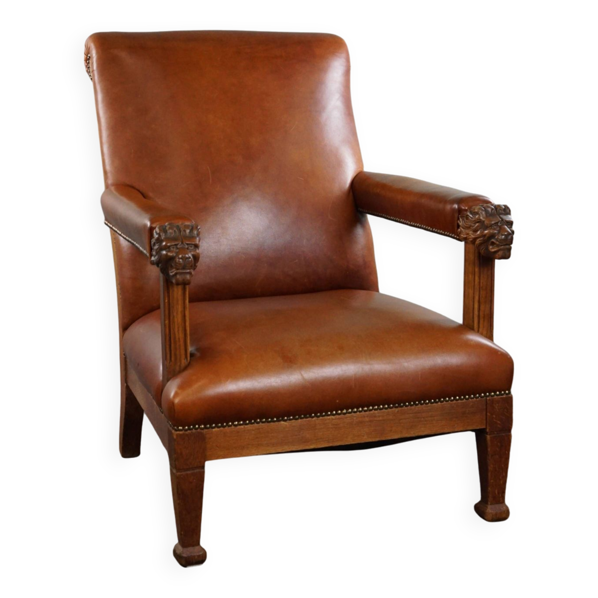 Armchair with lion heads reupholstered in cognac-colored cowhide leather