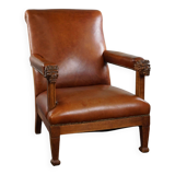 Armchair with lion heads reupholstered in cognac-colored cowhide