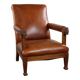 Armchair with lion heads reupholstered in cognac-colored cowhide leather
