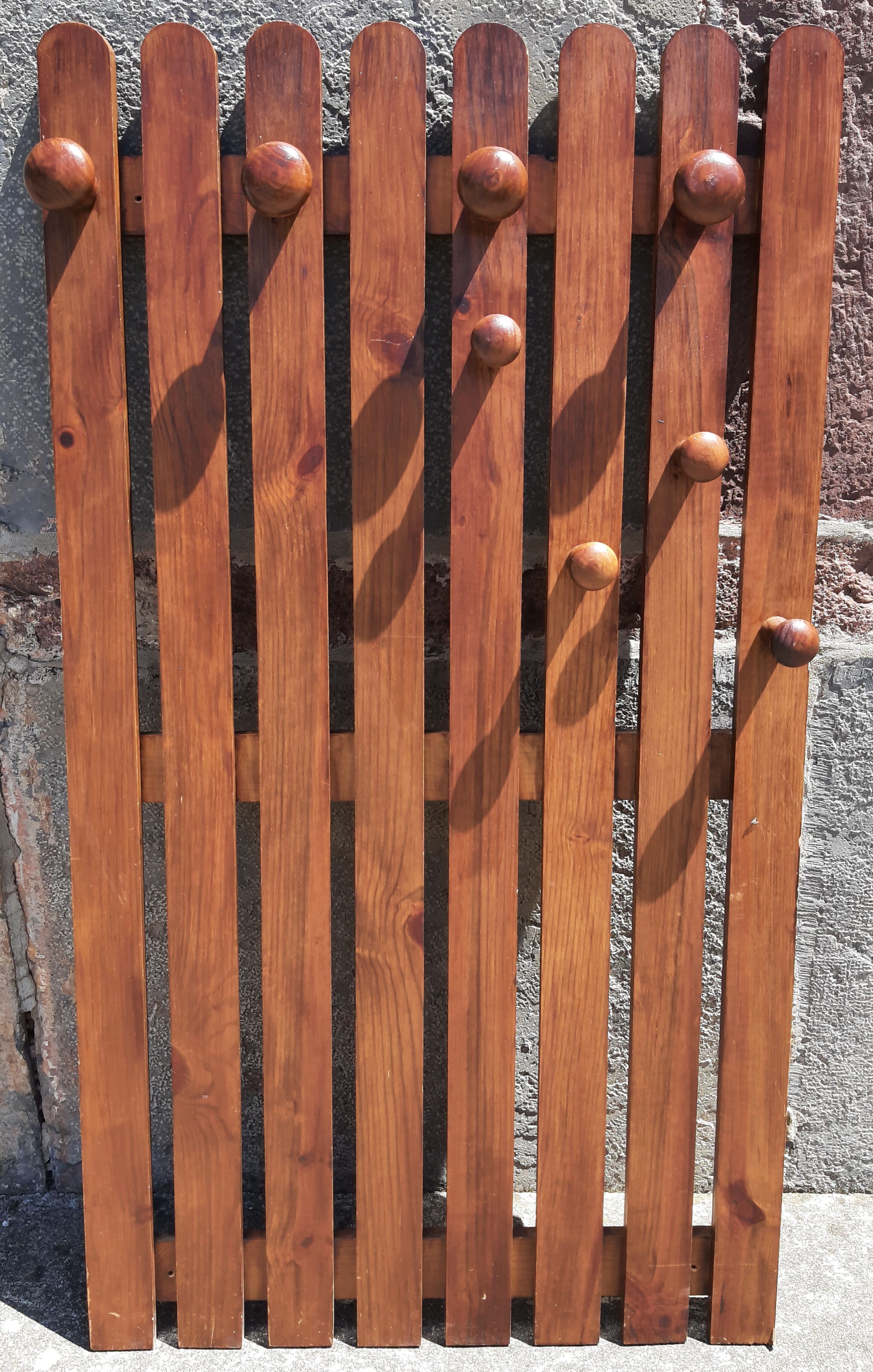 Wall-mounted coat rack in wood or wall hook.