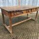 Old chestnut table with 3 front drawers and a cat bar.
