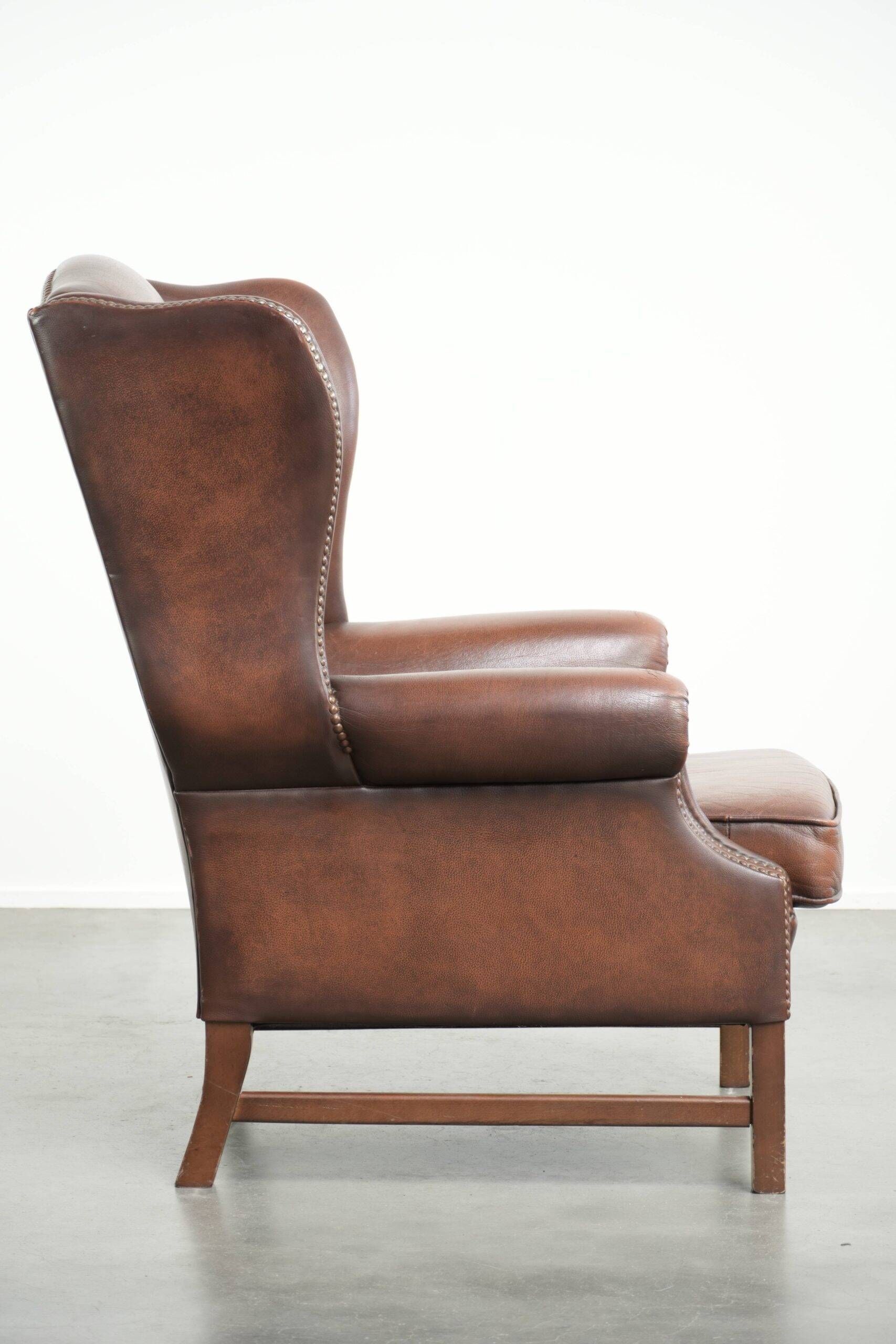 Comfortable cowhide wingback armchair in English style with a timeless look