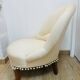 Pale pink upholstered armchair with wooden legs.