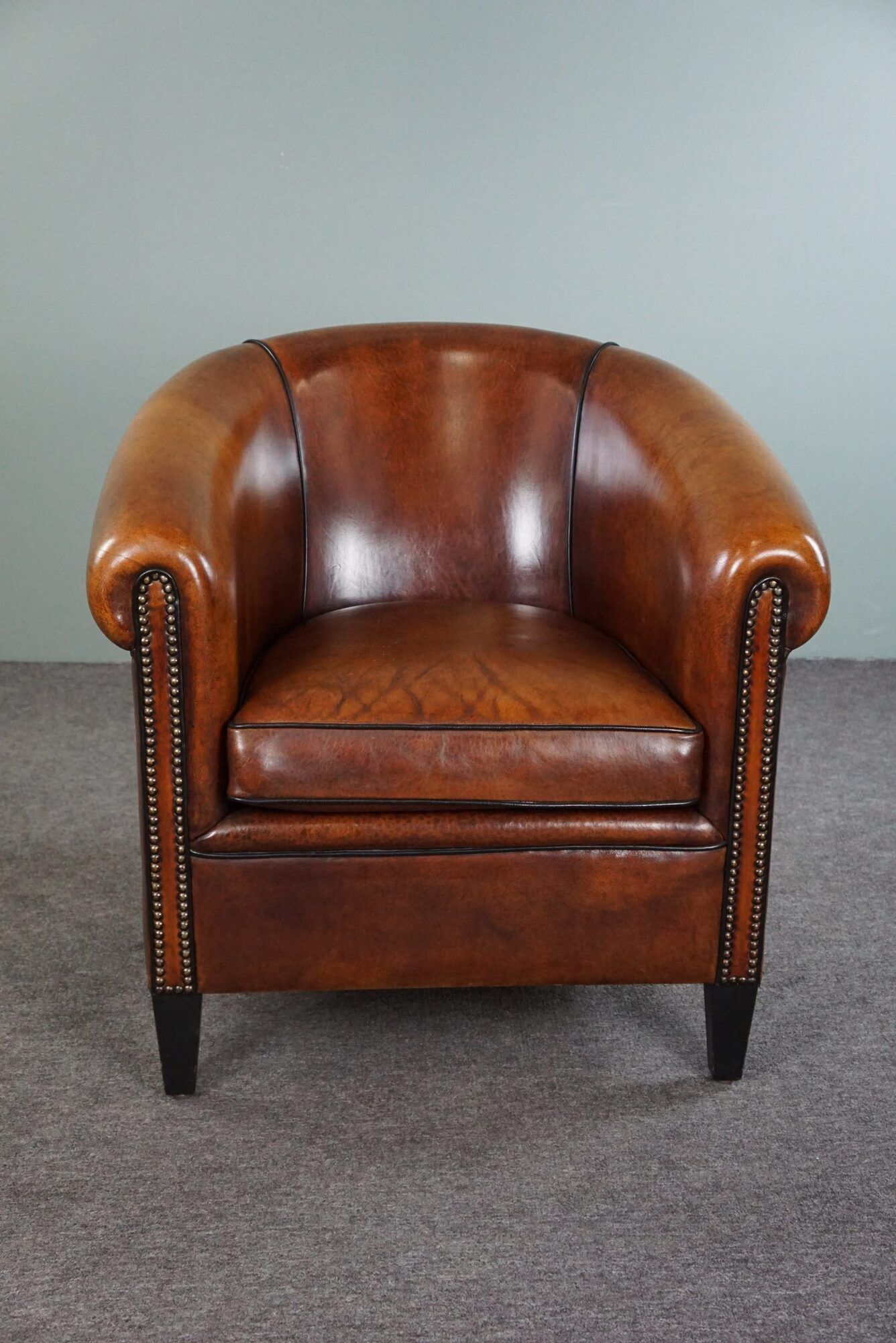 Club armchair in sheepskin with black piping
