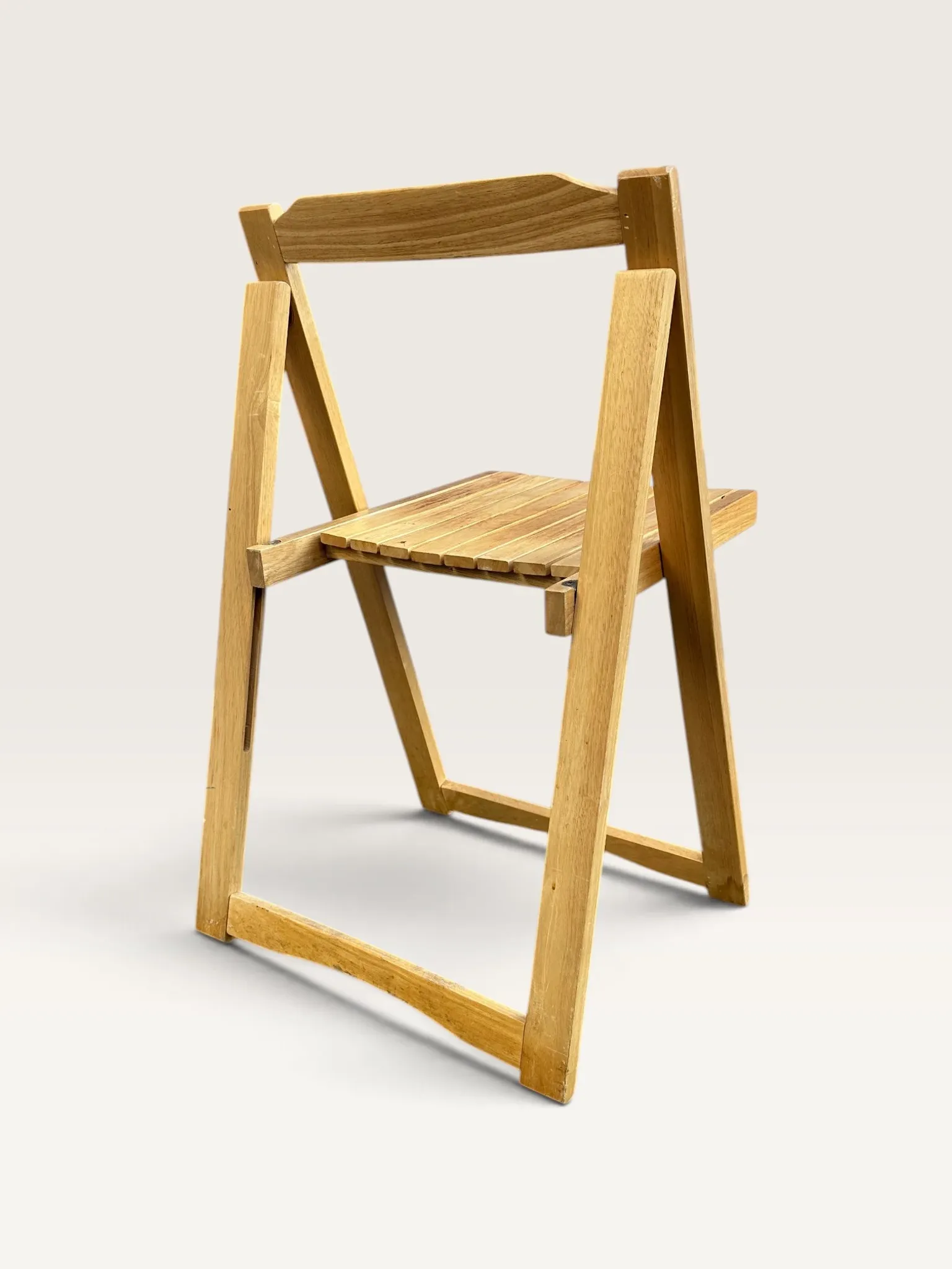 Blonde wooden folding chair in the style of Aldo Jacober.