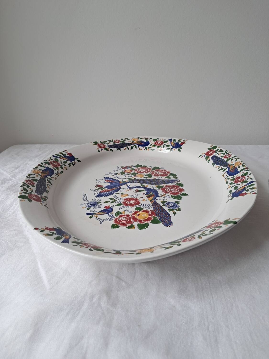 Large oval white ceramic platter, decorated with peacocks and vintage flowers