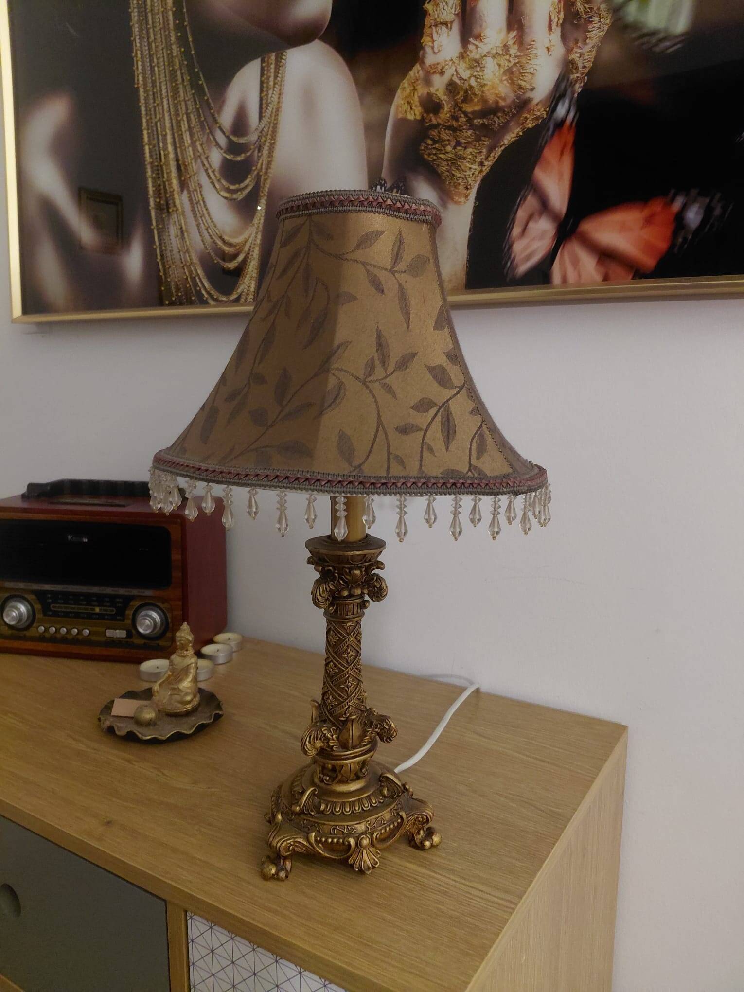Golden baroque-style table lamp with a shade adorned with pendants.