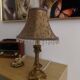 Golden baroque-style table lamp with a shade adorned with pendants.