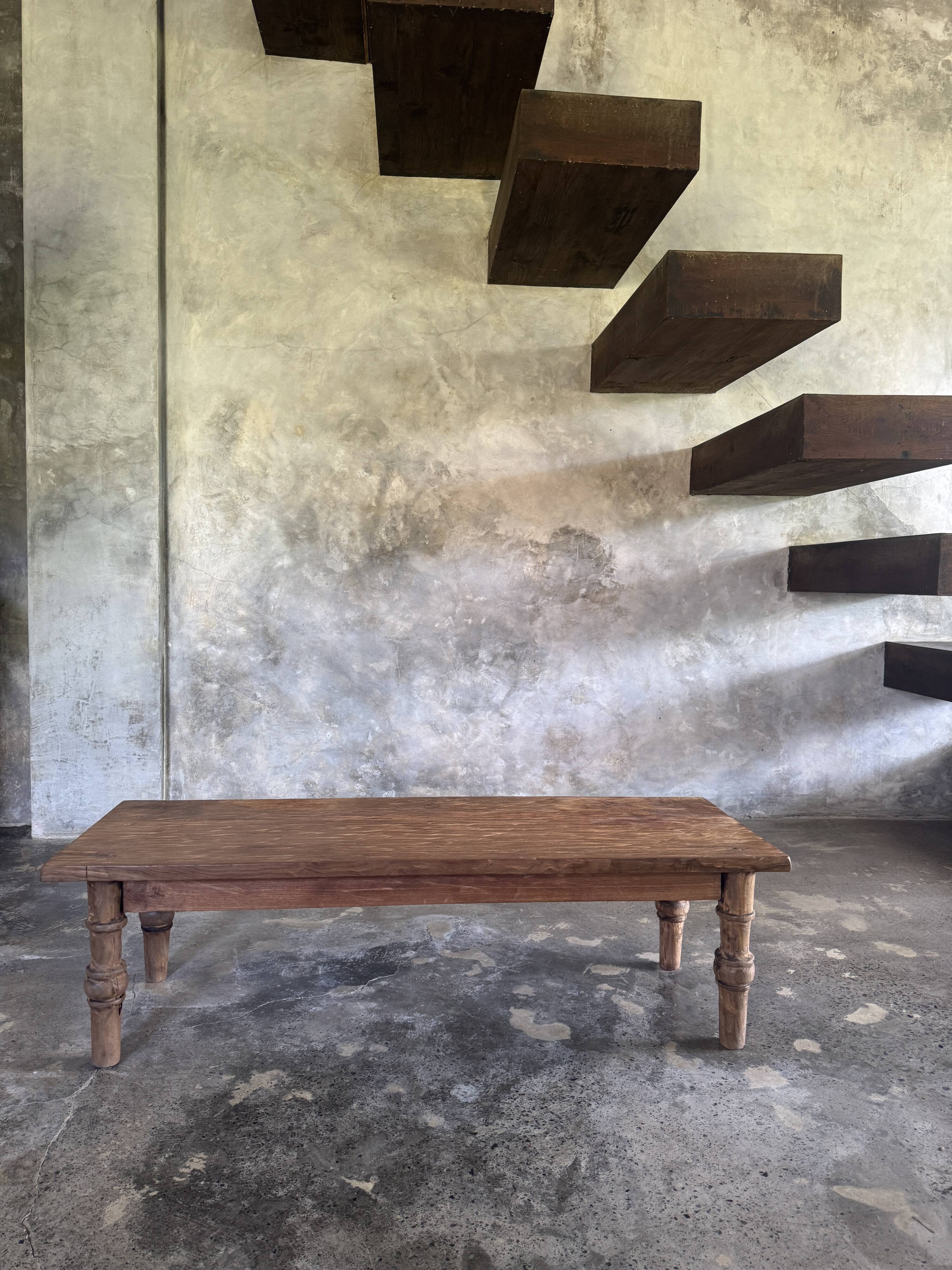 Brown Indonesian teak coffee table, with a border and cylindrical legs H40 L103.