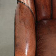 Unique sheepskin armchair with warm deep colours finished with black piping
