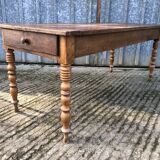 Antique farmhouse table in solid cherry wood with turned legs.