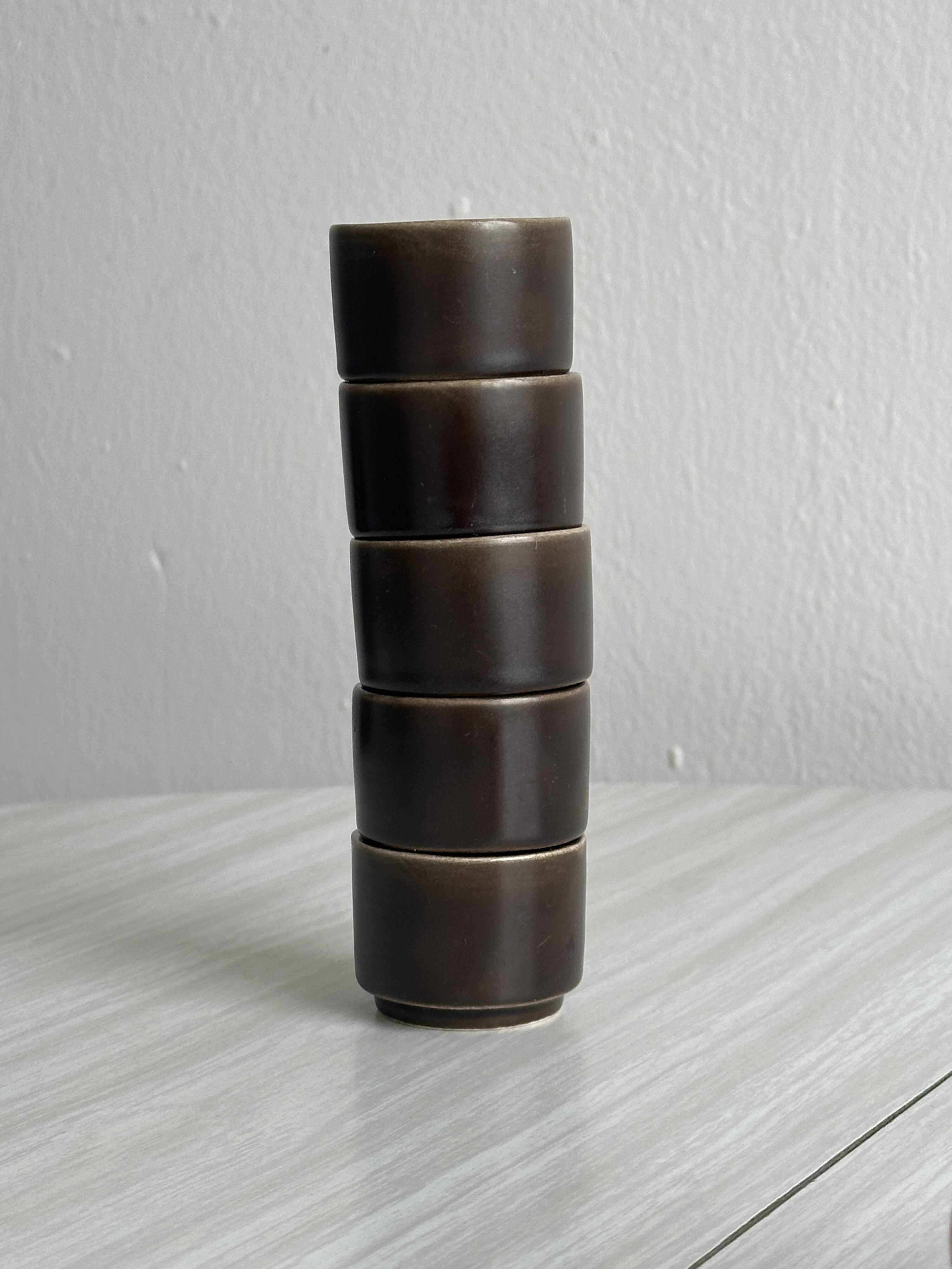Set of 5 dark brown glazed ceramic egg cups.