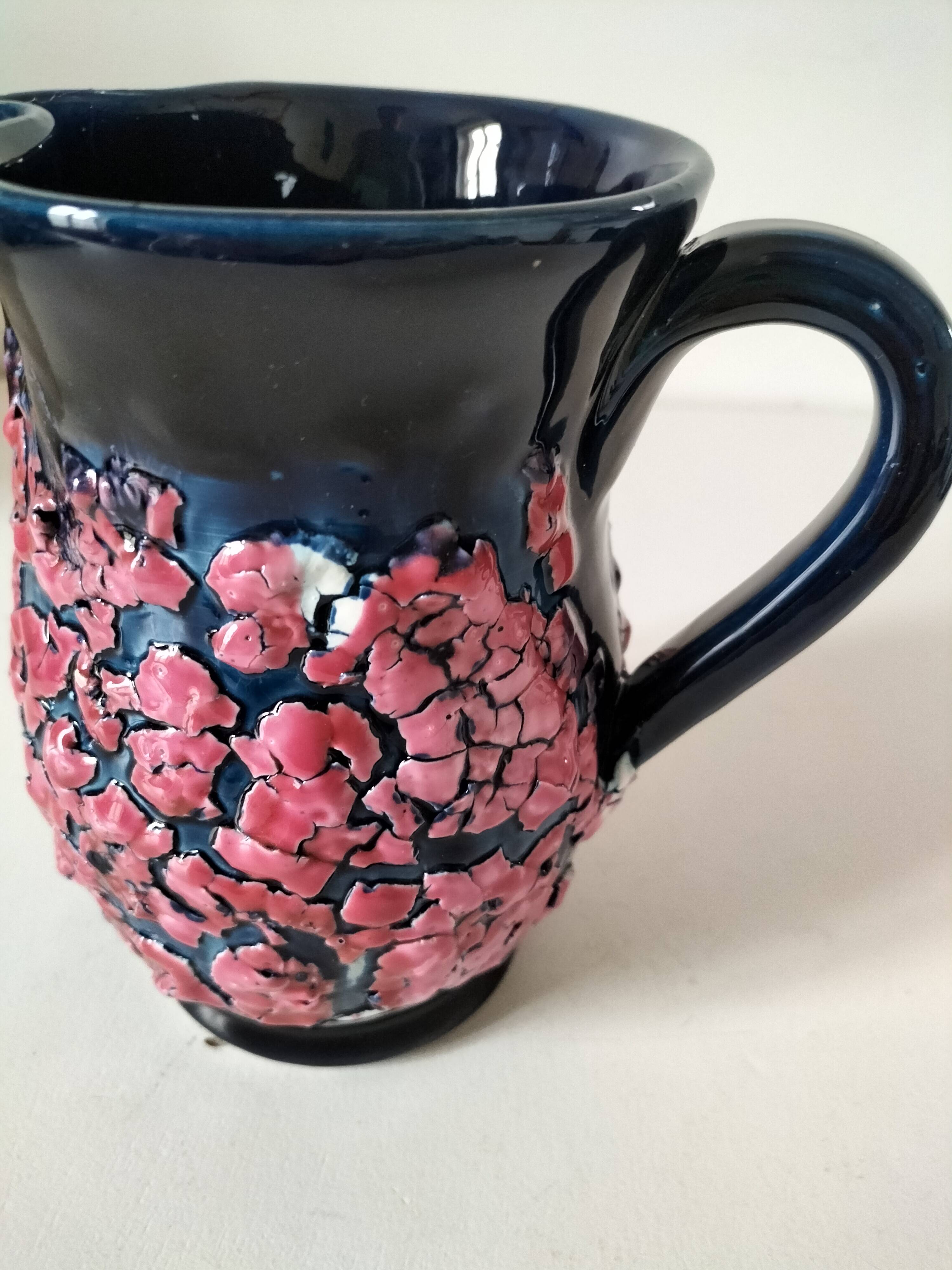 Vintage pitcher in midnight blue glazed ceramic with bright pink relief
