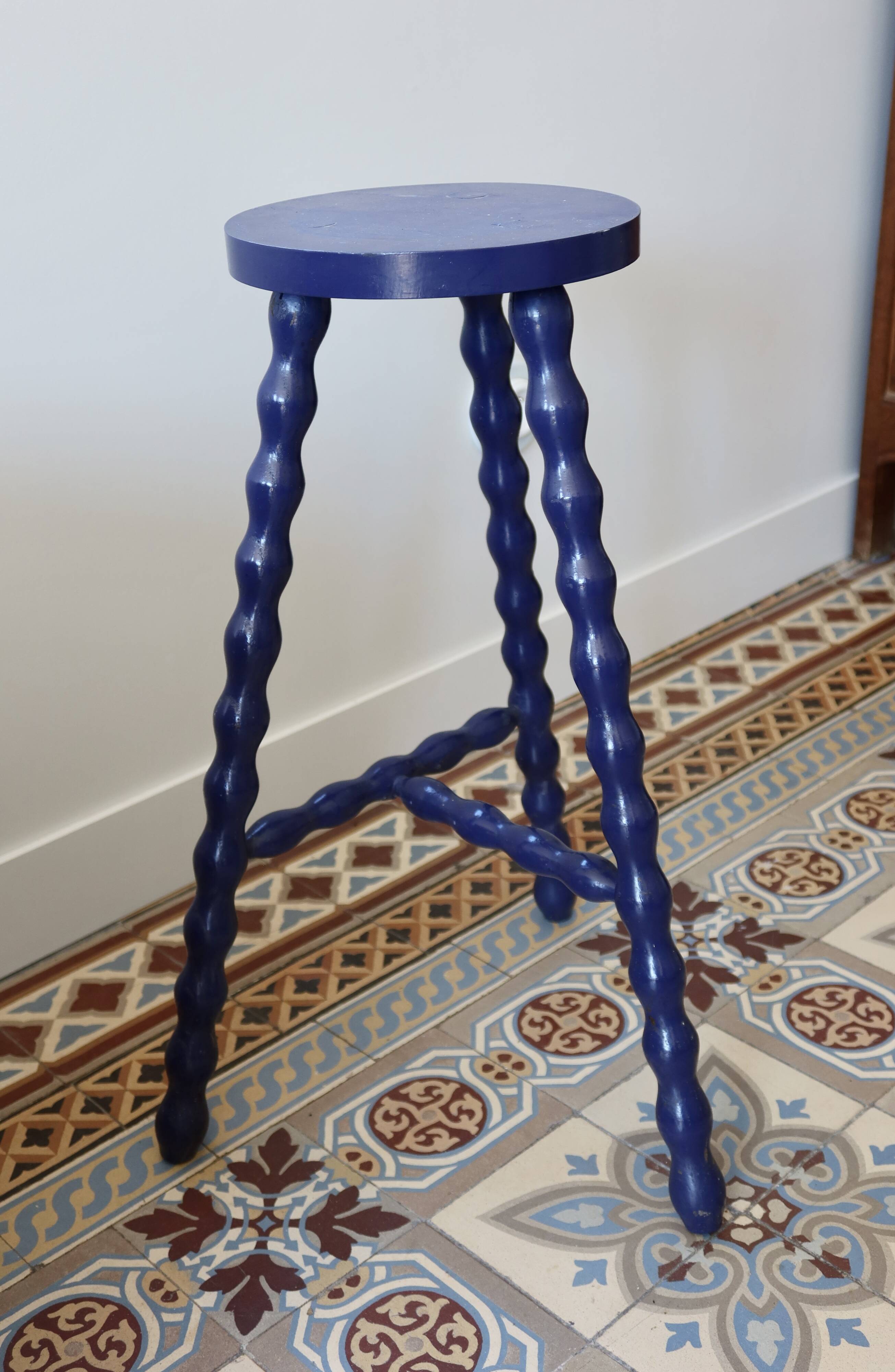 Vintage tripod stool made of turned wood, painted blue.