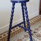 Vintage tripod stool made of turned wood, painted blue.