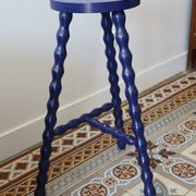 Vintage tripod stool made of turned wood, painted blue.