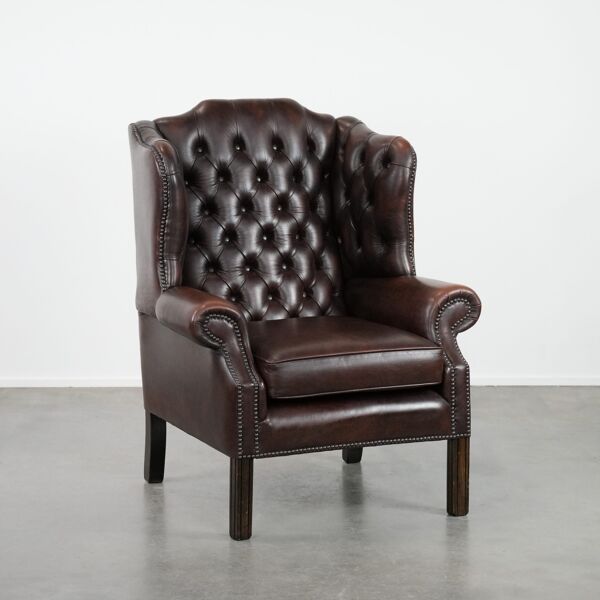 Fauteuil à oreilles Chesterfield en cuir de vachette marron dans le style anglais.