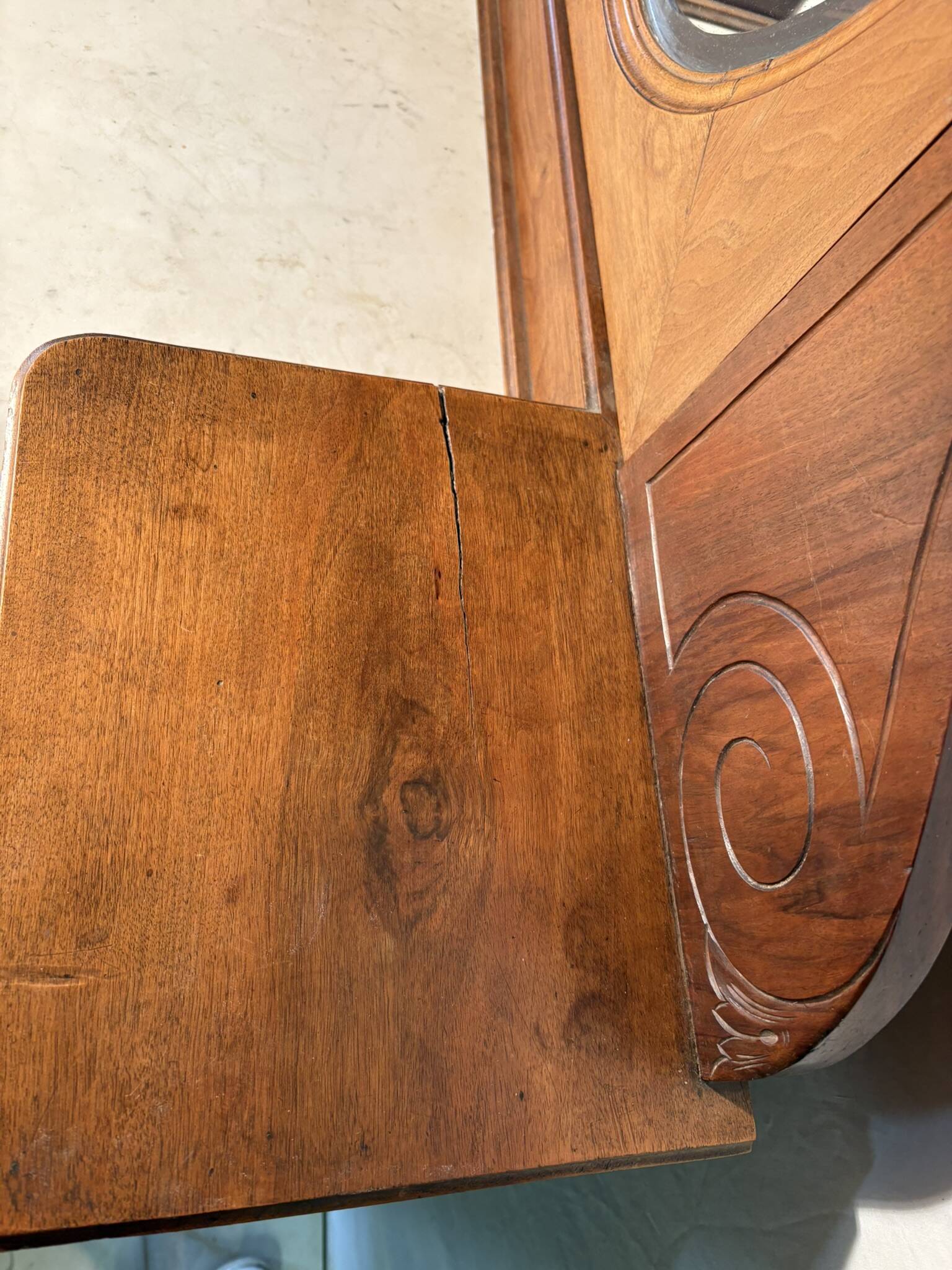 Antique carved wooden dressing table with marble and tilting oval mirror.