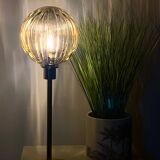 Table lamp with a gold-trimmed globe and a black base