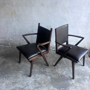 Pair of sculptural mid-century armchairs in dark wood and brown upholstery.