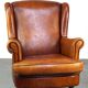 Fauteuil en cuir de mouton subtil et bien entretenu sur roulettes avant en laiton
