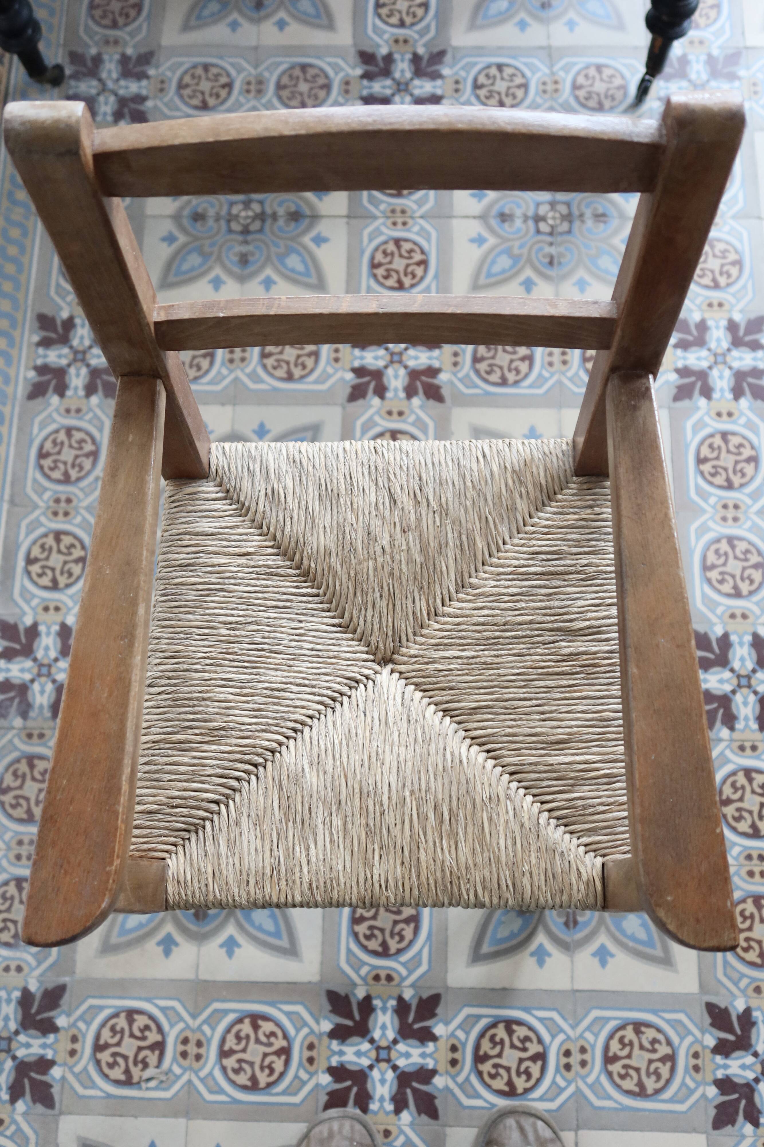 Vintage wooden high chair for children with a straw seat.