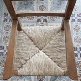 Vintage wooden high chair for children with a straw seat.