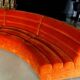 Burnt orange modular sofa for four with a futuristic design.