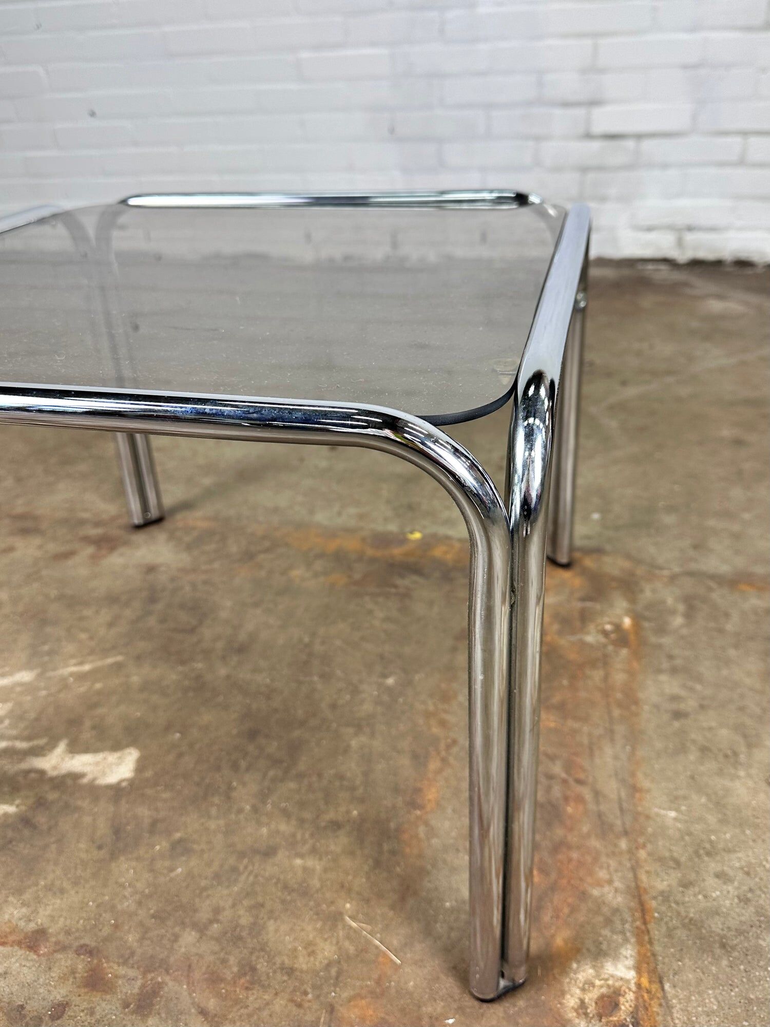 Table basse vintage en métal chromé et verre fumé