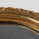 French Baroque style oval mirror in gilded wood with floral decorations