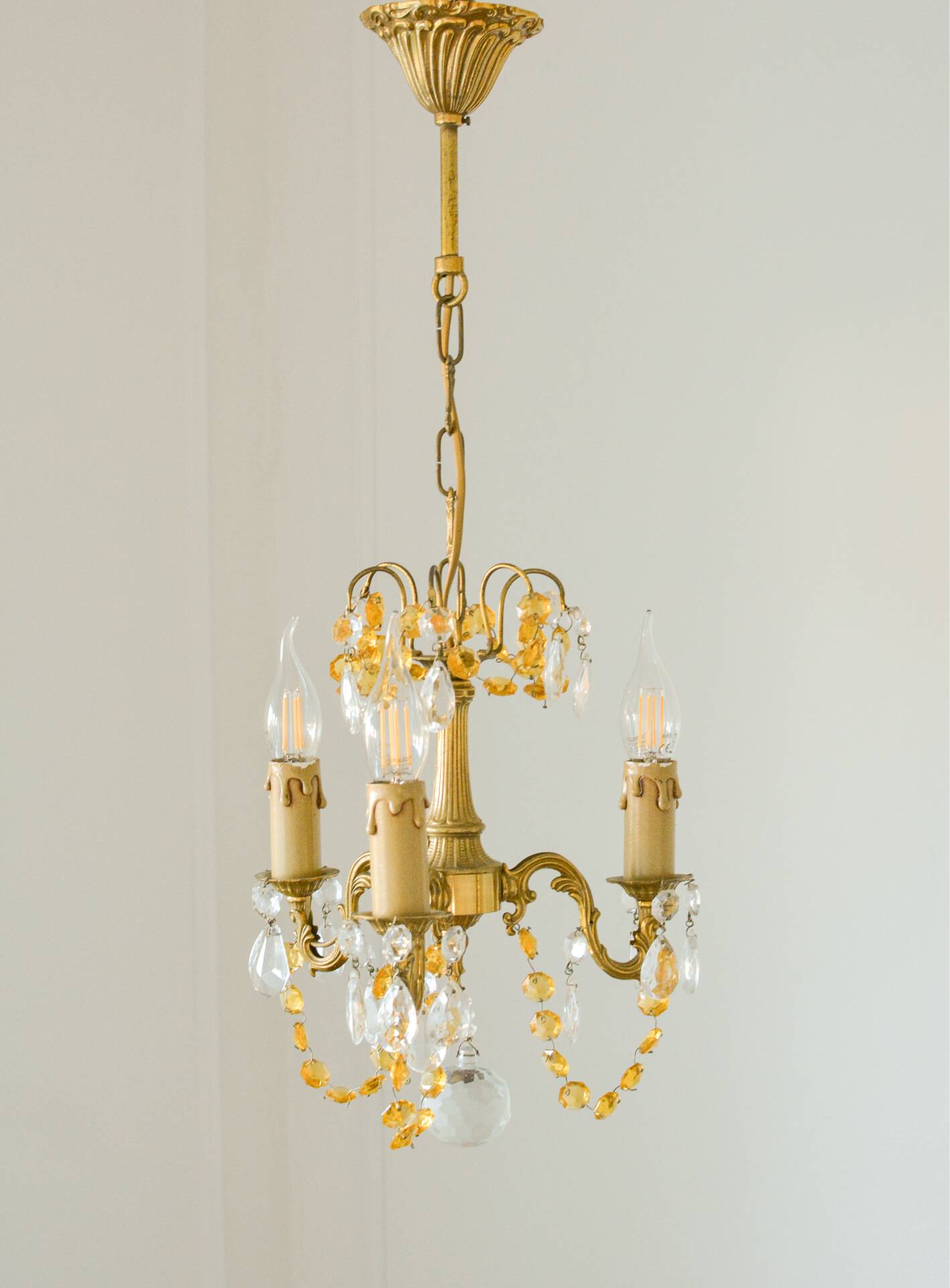 Small vintage brass chandelier with amber crystal pendants.