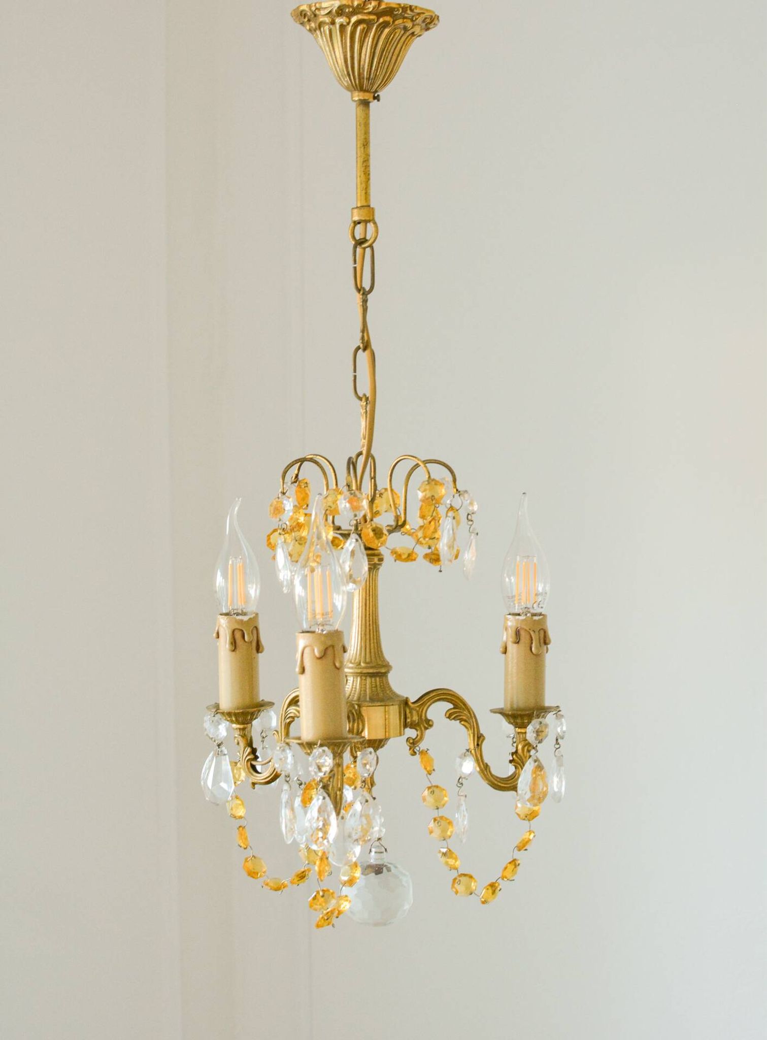 Small vintage brass chandelier with amber crystal pendants.