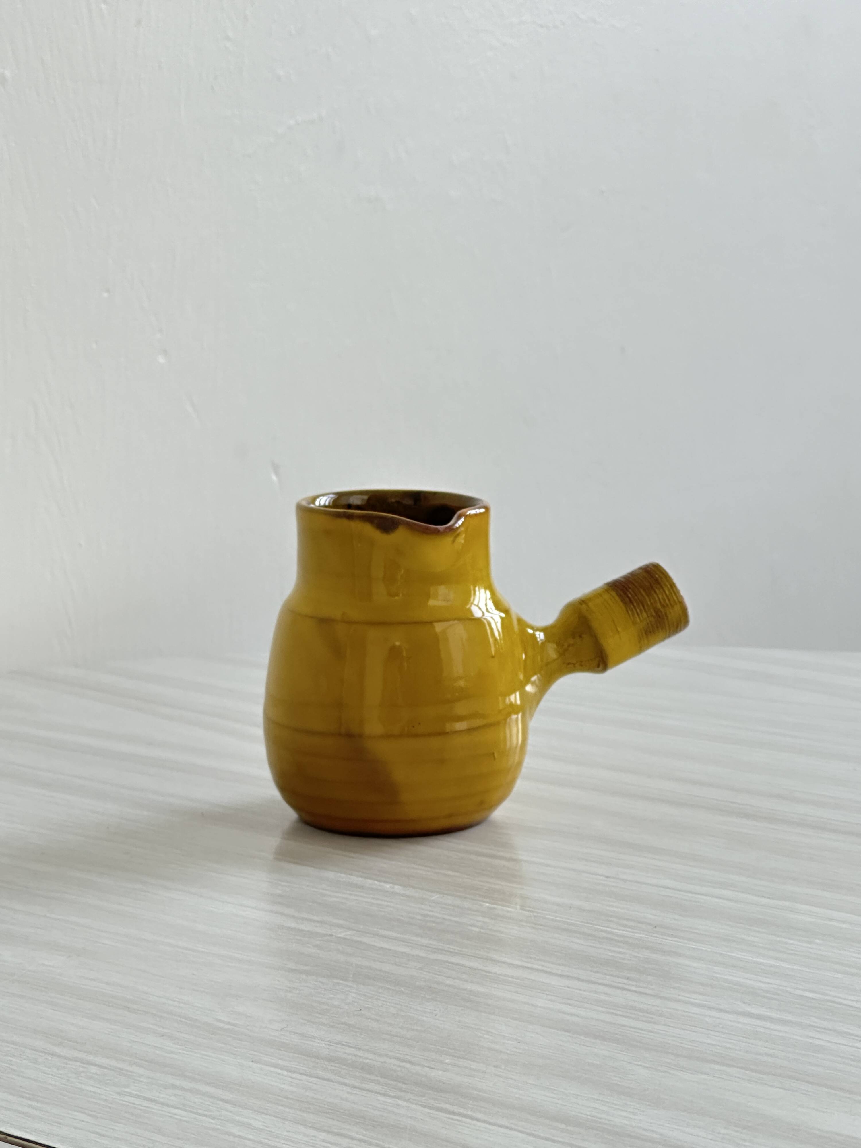Yellow glazed ceramic sauce boat or milk jug