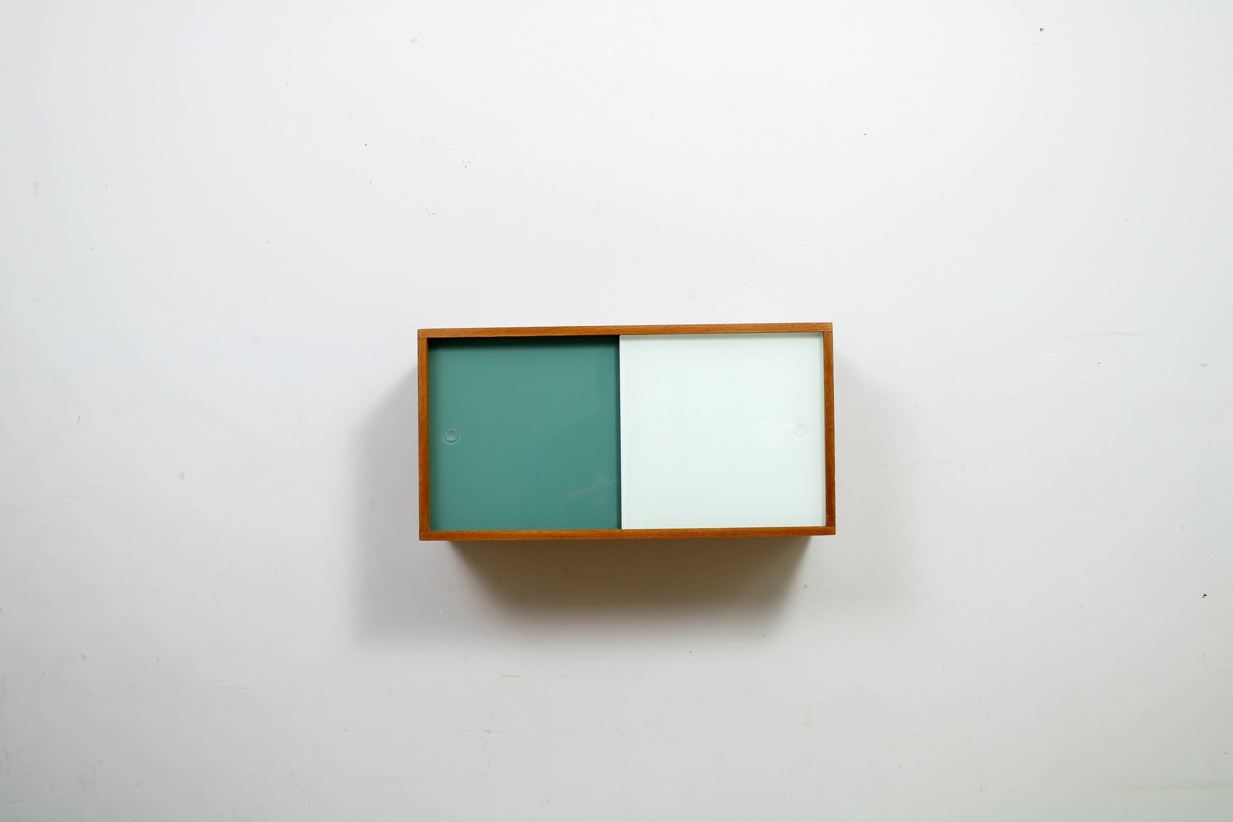A vintage mid-century wall hung oak cabinet, green & white glass doors