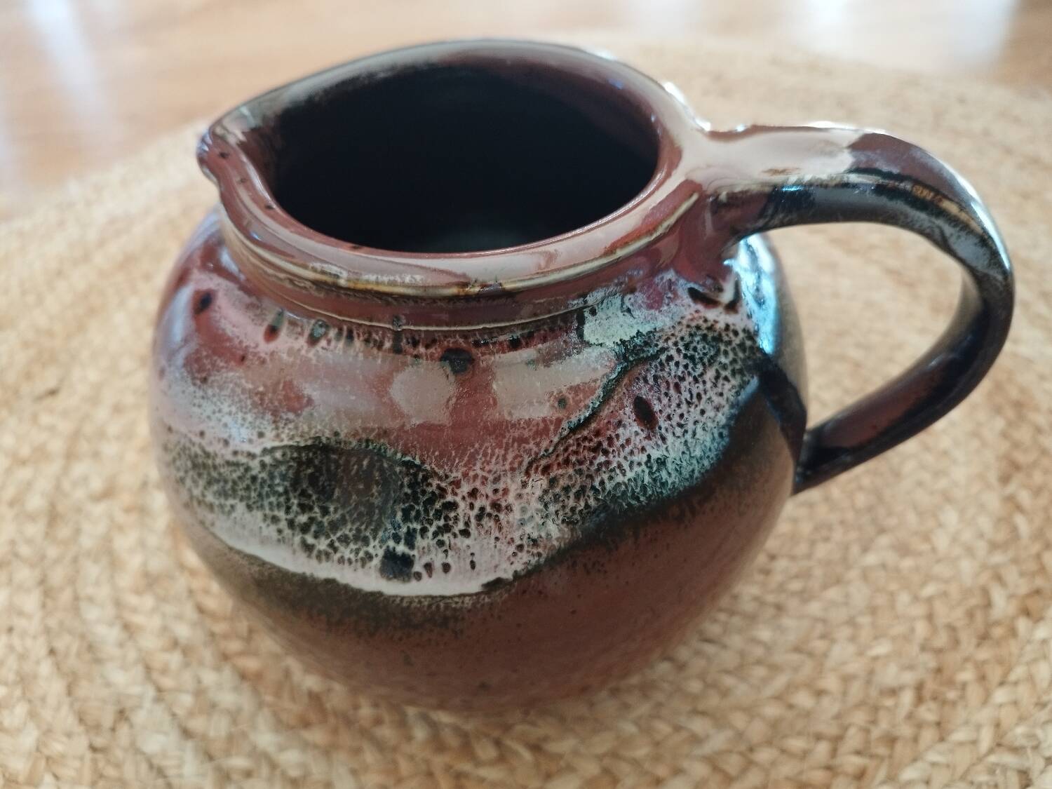 Stoneware pitcher by Matthieu Liévois in shades of red