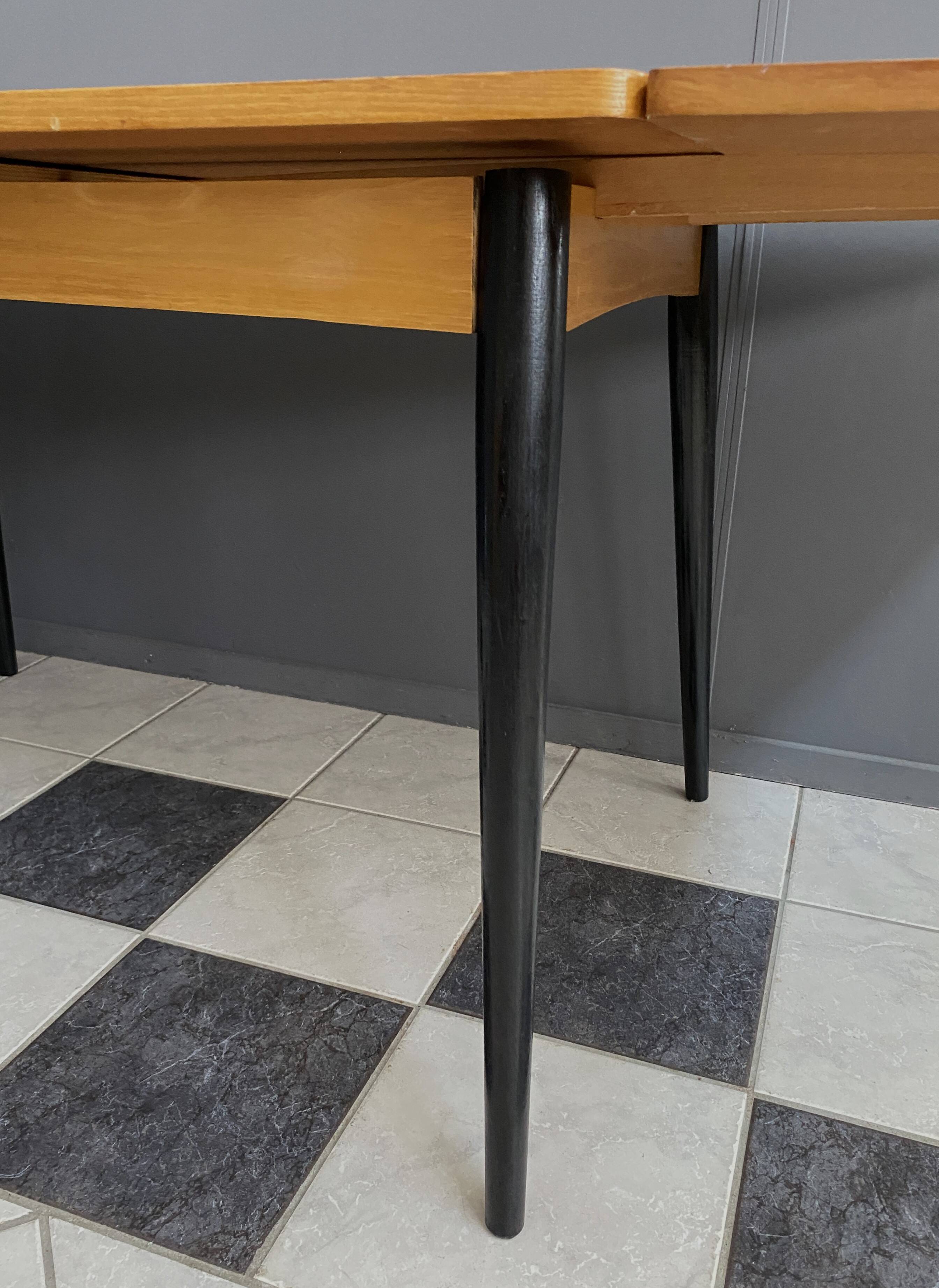 Wood enlarging dining table black wood legs 1960s