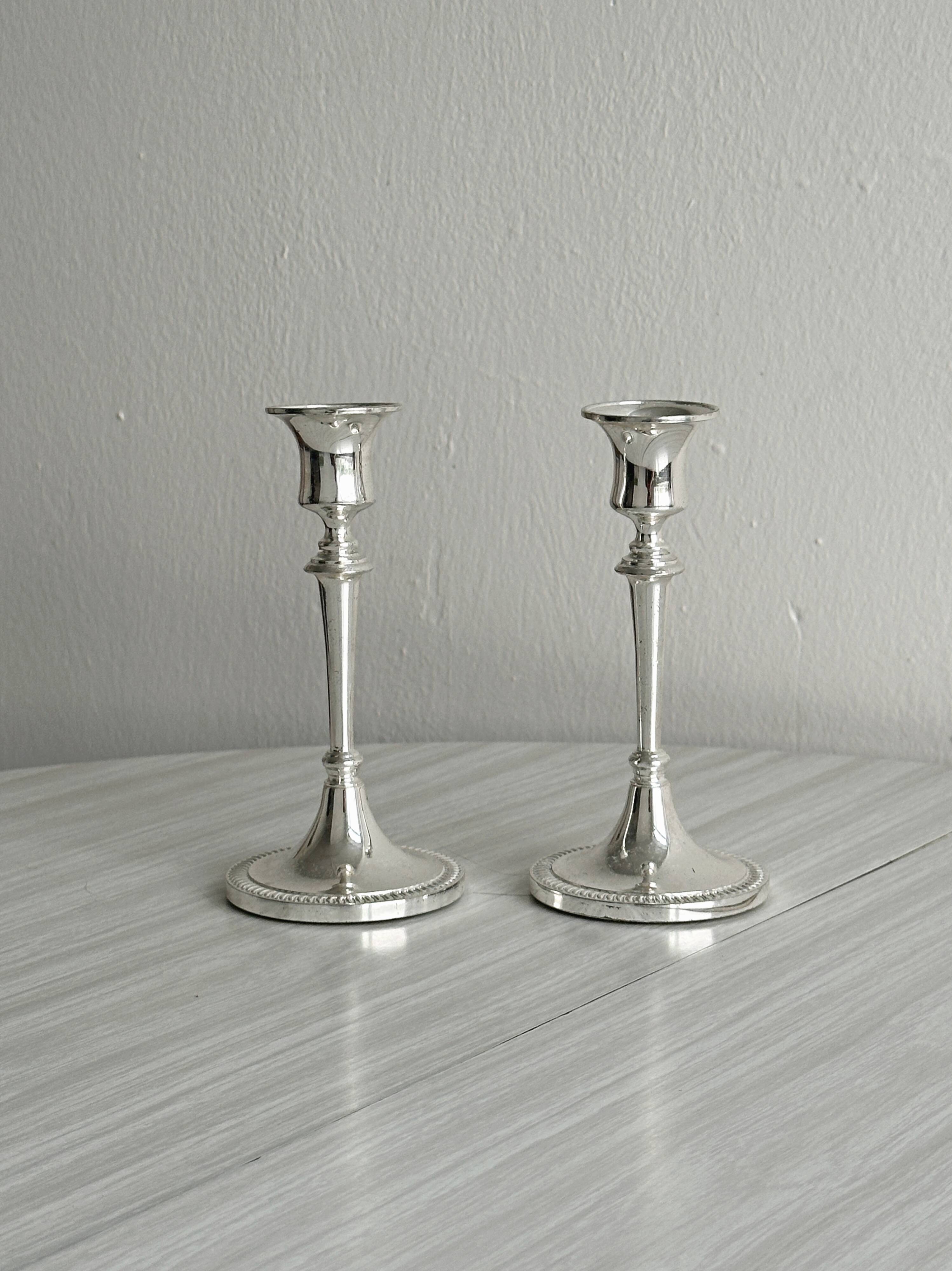 Pair of white metal candlesticks