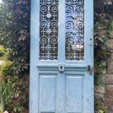 Entrance door in solid oak, cast iron grille, 1930s
