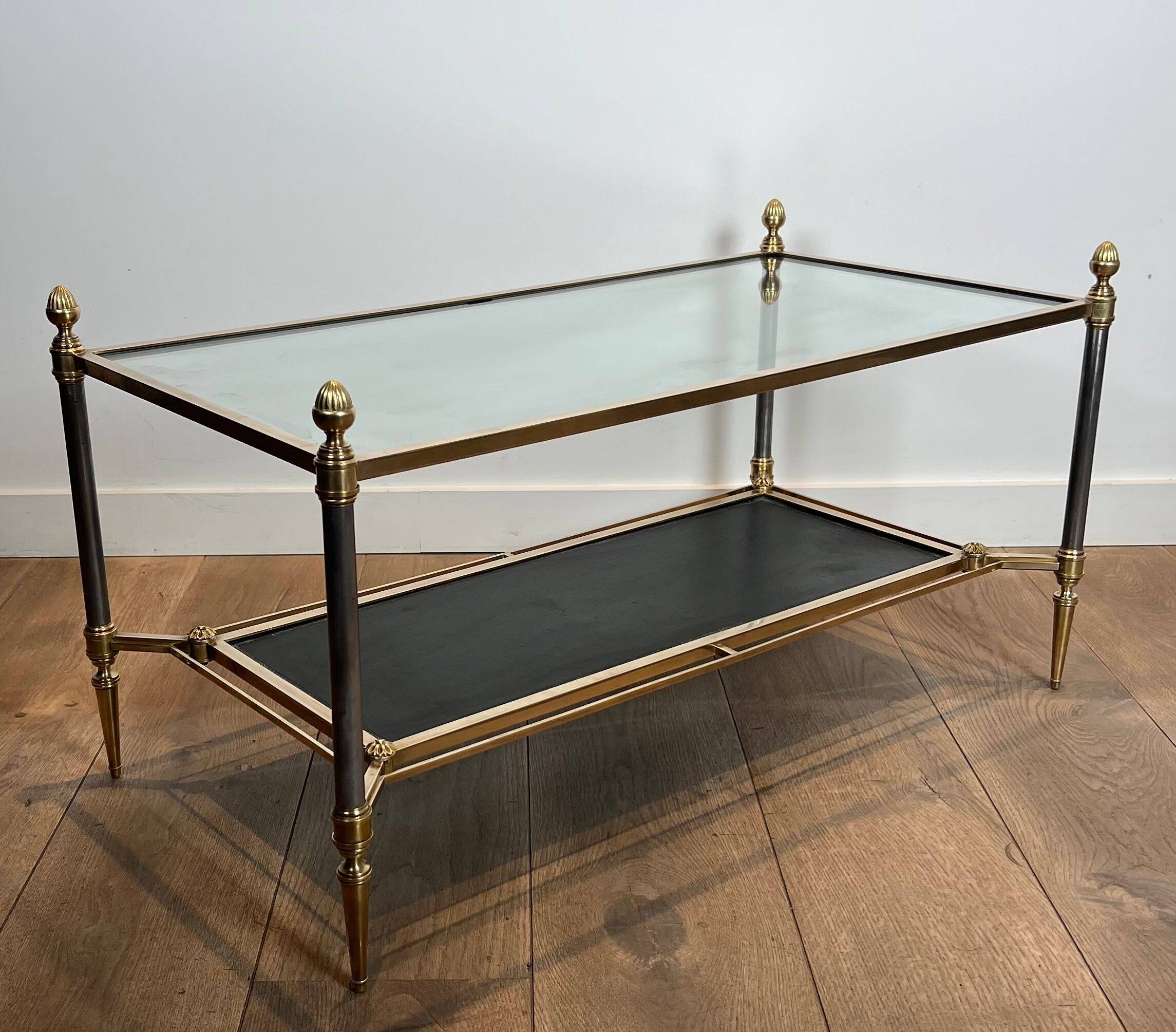 Brass coffee table with a black leather top and golden edges from Maison Jansen.
