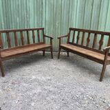 Duo of old solid oak benches with backs and armrests.