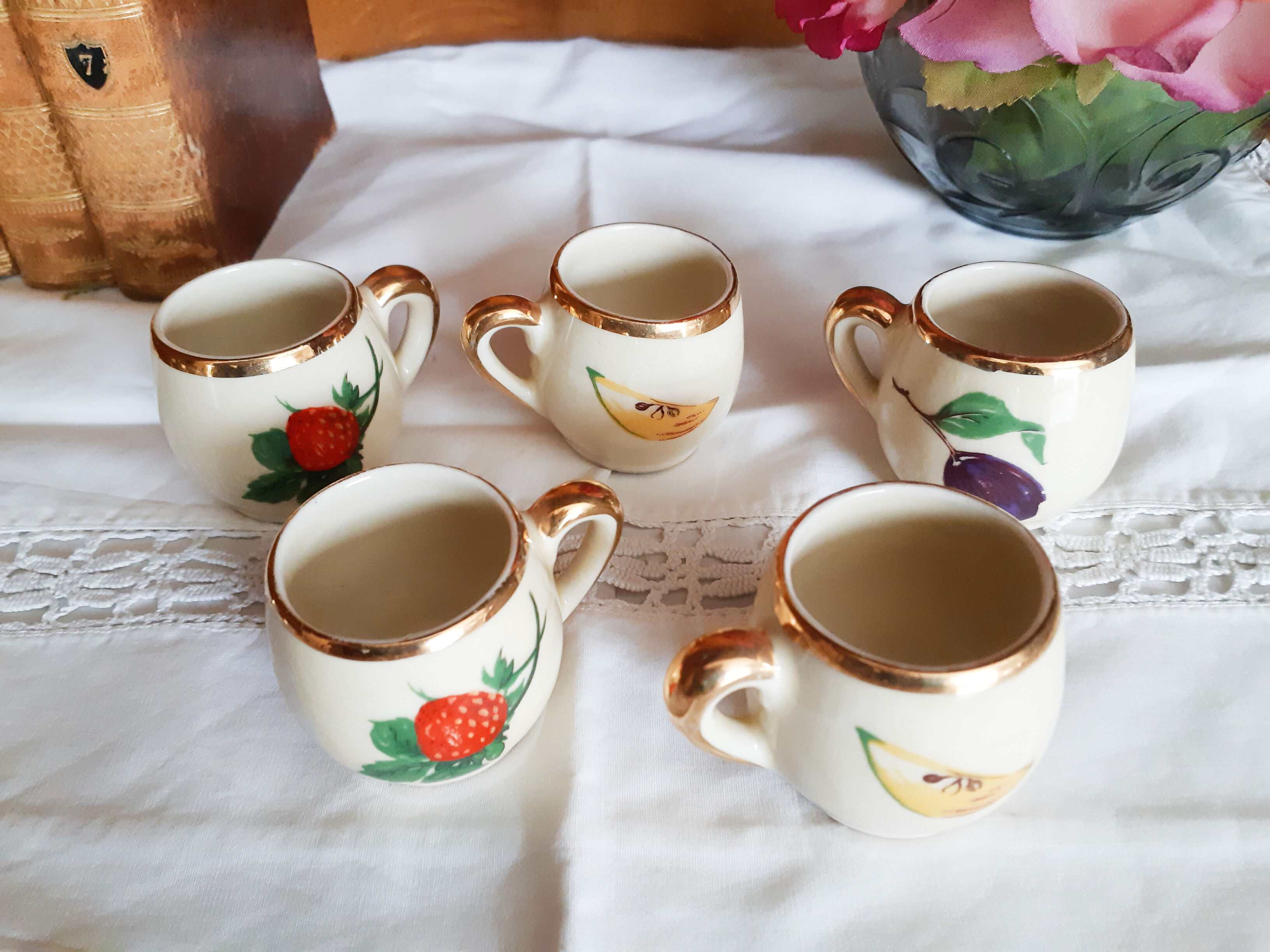 5 antique cups with liquor, porcelain fruits
