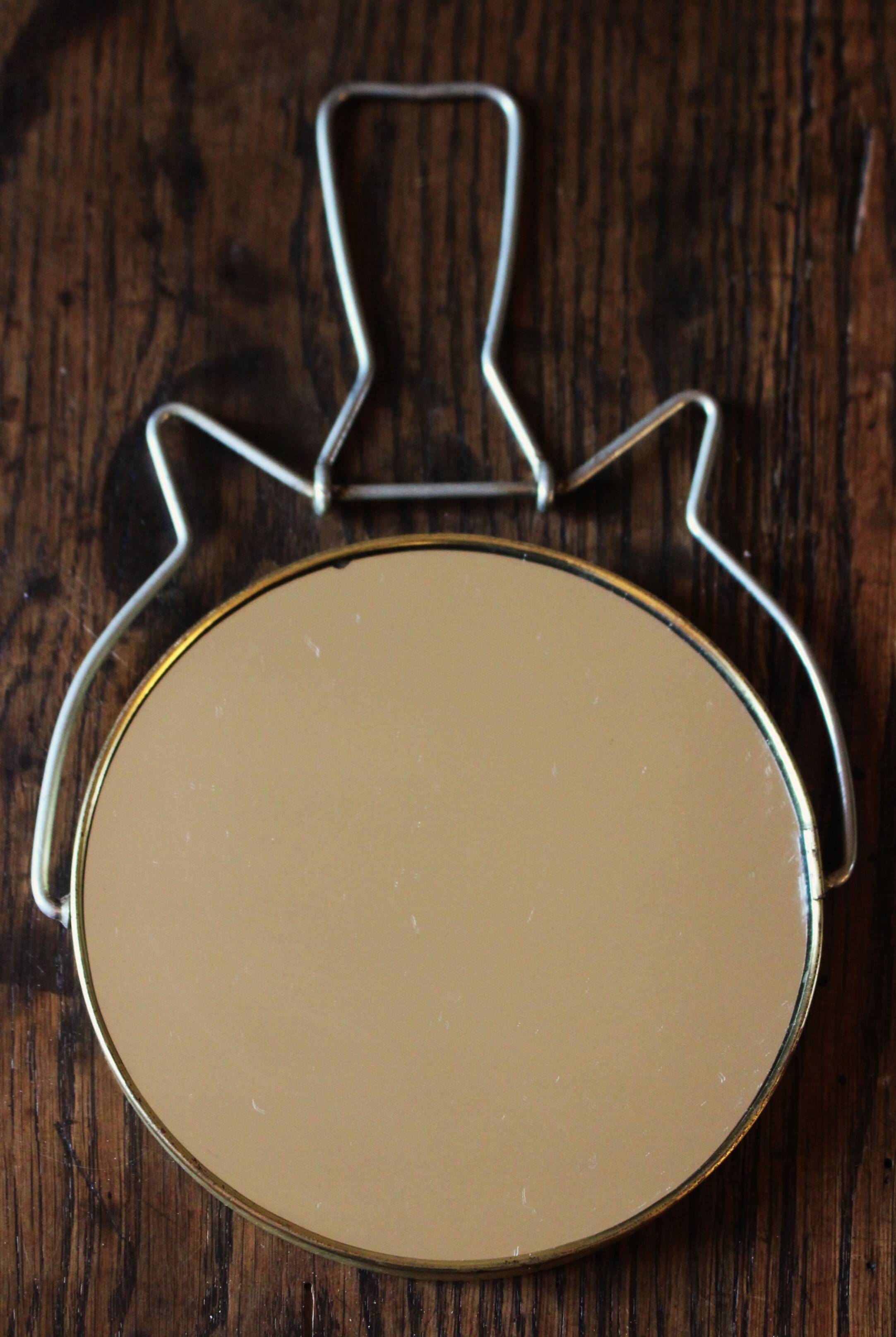 Antique round barber mirror in gilded metal