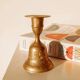 Brass candlestick in the shape of a bell.