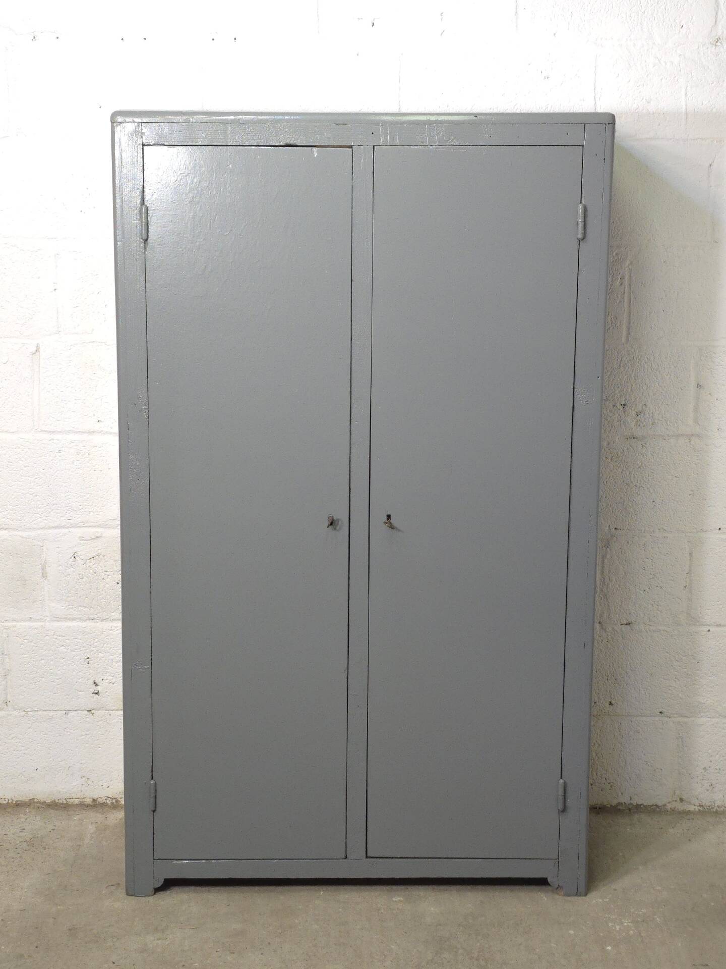 Curved wardrobe workshop locker made of wood repainted in grey.